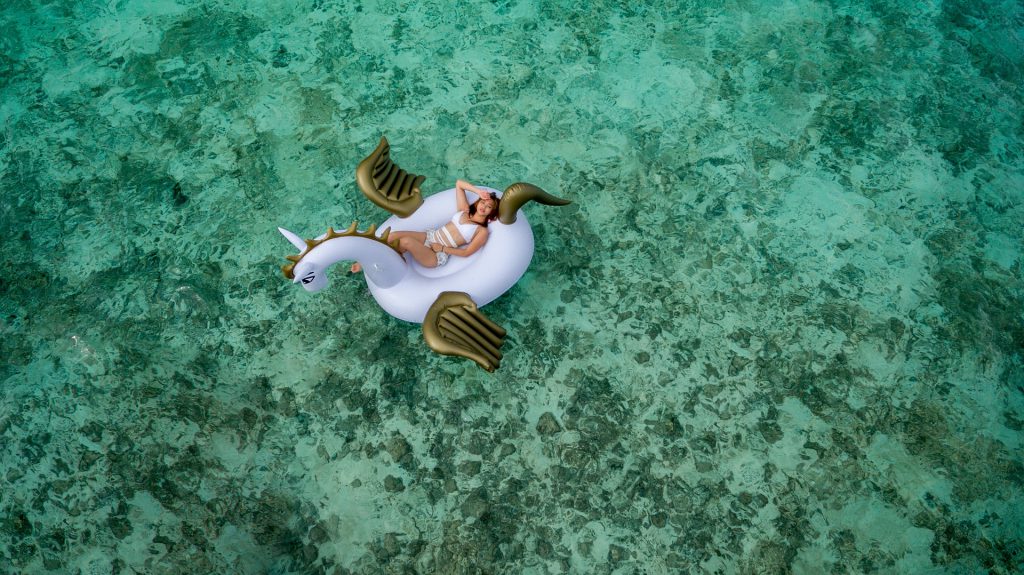 Femme sur une bouée licorne au milieu de la mer